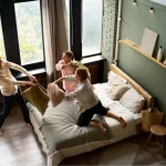 Rodzina spędzająca wspólny czas w sypialni apartamentu rodzinnego we Wrocławiu.