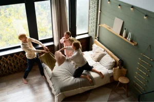 Rodzina spędzająca wspólny czas w sypialni apartamentu rodzinnego we Wrocławiu.