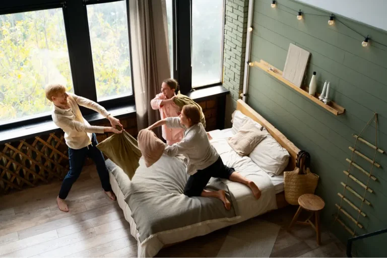 Rodzina spędzająca wspólny czas w sypialni apartamentu rodzinnego we Wrocławiu.